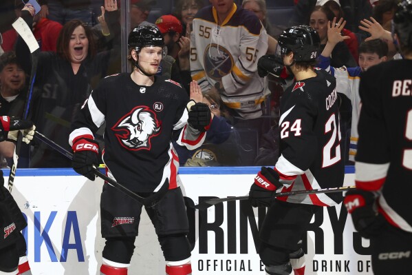 Buffalo Sabres defenseman Bowen Byram (4) celebrates his goal with center Dylan Cozens (24) during the first period of an NHL hockey game against the Detroit Red Wings Tuesday, March 12, 2024, in Buffalo, N.Y. (AP Photo/Jeffrey T. Barnes)