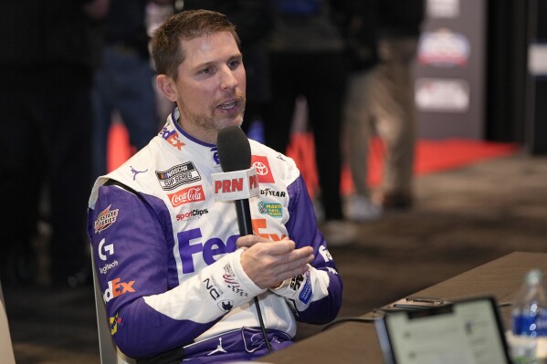 Denny Hamlin takes part in an interview during NASCAR Daytona 500 auto racing media day at Daytona International Speedway, Wednesday, Feb. 14, 2024, in Daytona Beach, Fla. (AP Photo/John Raoux)