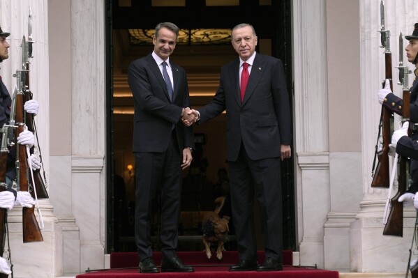 FILE - Greece's Prime Minister Kyriakos Mitsotakis, left, welcomes the Turkey's President Recep Tayyip Erdogan before their meeting at Maximos Mansion in Athens, Greece, Thursday, Dec. 7, 2023. Old foes Turkey and Greece will test a five-month-old friendship initiative on Monday, May 13, 2024 when Greek Prime Minister Kyriakos Mitsotakis visits Ankara. (AP Photo/Thanassis Stavrakis, File)