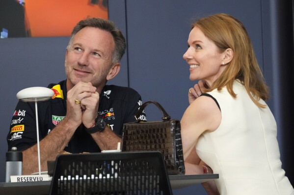 Red Bull team principal Christian Horner, left, speaks with his wife Geri Halliwell prior to the Formula One Bahrain Grand Prix at the Bahrain International Circuit in Sakhir, Bahrain, Saturday, March 2, 2024. (AP Photo/Darko Bandic)