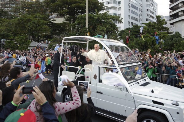 FILE - Pope Francis waves to people from his popemobile along the Copacabana beachfront as he arrives for the Stations of the Cross procession in Rio de Janeiro, Brazil, Friday, July 26, 2013. When Pope Francis made the first foreign trip of his papacy, to Rio de Janeiro for World Youth Day in 2013, he urged young people to make a 