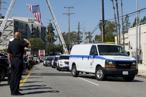 A procession honoring Manhattan Beach Officer Chad Swanson arrives at the Los Angeles County Coroner's office on Wednesday, Oct. 4, 2023. Swanson, who was a hero of the 2017 Las Vegas mass shooting, died Wednesday when his motorcycle was hit by a car on a Los Angeles-area highway, authorities said. (Dean Musgrove/The Orange County Register via AP)