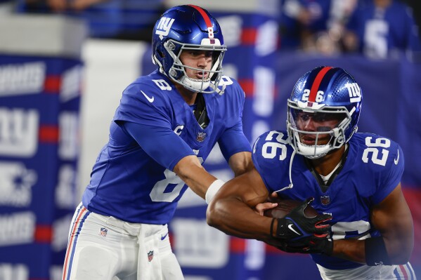 New York Giants quarterback Daniel Jones, left, hands off to Saquon Barkley during warm ups before an NFL football game against the Dallas Cowboys, Sunday, Sept. 10, 2023, in East Rutherford, N.J. (AP Photo/Adam Hunger)