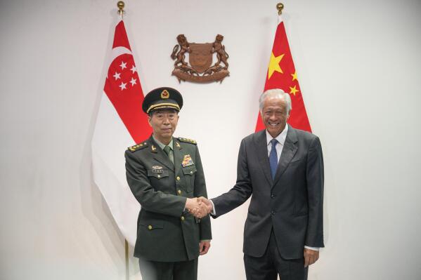 Chinese Defense Minister Gen. Li Shangfu, left, shakes hands with Singapore Defense Minister Ng Eng Hen in Singapore, Thursday, June 1, 2023. China and Singapore laid the groundwork Friday for a hotline between the two countries that would establish a high-level communications link between Beijing and a close American partner in Asia at a time when Chinese tensions with Washington are high and dialogue has stalled. (AP Photo/Vincent Thian)