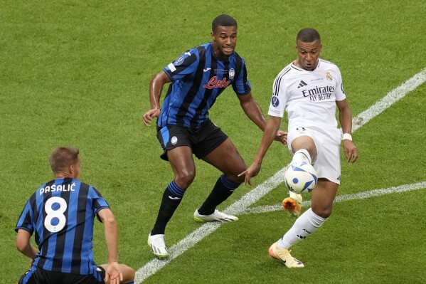 Real Madrid's Kylian Mbappe, right, controls the ball next to Atalanta's Isak Hien during the UEFA Super Cup Final soccer match between Real Madrid and Atalanta at the Narodowy stadium in Warsaw, Poland, Wednesday, Aug. 14, 2024. (AP Photo/Darko Vojinovic)