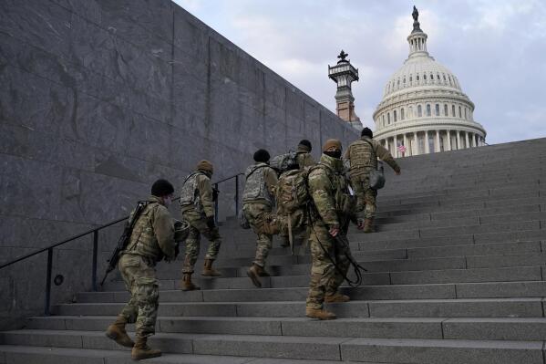 FILE - National Guard members take a staircase toward the U.S. Capitol building before a rehearsal for President-elect Joe Biden's Presidential Inauguration in Washington, Jan. 18, 2021. Soldiers are leaving the Army National Guard at a faster rate than they are enlisting, fueling concerns that in the coming years units around the country may not meet military requirements for overseas and other deployments. Officials say the number of soldiers retiring or leaving the Guard each month in the past year has exceeded those coming in, for a total annual loss of about 7,500 service members. (AP Photo/Patrick Semansky, File)