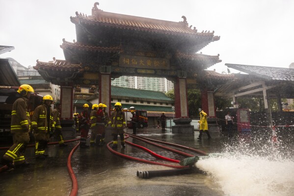 Fire-fighters drain out water following heavy rainstorms in Hong Kong, Friday, Sept. 8, 2023. Rain pouring onto Hong Kong and southern China overnight flooded city streets and some subway stations, halting transportation and forcing schools to close Friday. (AP Photo/Louise Delmotte)