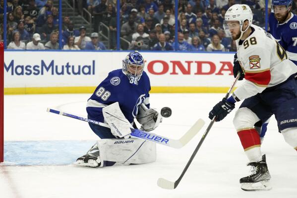 Tampa Bay Lightning goaltender Andrei Vasilevskiy (88) makes a save on a shot as Florida Panthers center Maxim Mamin (98) goes or the rebound during the first period in Game 4 of an NHL hockey second-round playoff series Monday, May 23, 2022, in Tampa, Fla. (AP Photo/Chris O'Meara)