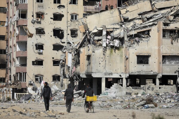 Palestinians walk through the destruction left by the Israeli air and ground offensive on the Gaza Strip in Gaza City, Saturday, Feb. 10, 2024. (AP Photo/Mohammed Hajjar)