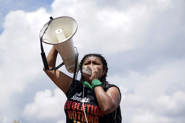 A person speaks into a megaphone before the Women's March in Washington, Saturday, June 24, 2023. Abortion rights and anti-abortion activists held rallies Saturday in Washington and across the country to call attention to the Dobbs v. Jackson Women’s Health Organization ruling on June 24, 2022, which upended the 1973 Roe v. Wade decision. (AP Photo/Stephanie Scarbrough)