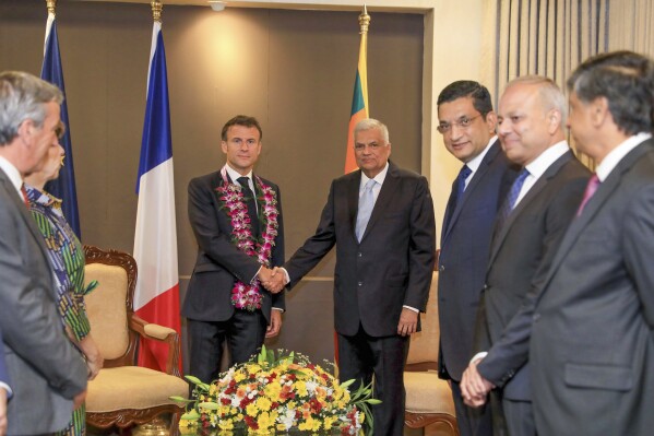 In this Handout photo released by Sri Lanka President's office shows, Sri Lankan President Ranil Wickermesinghe shakes hand with his French counterpart Emmanuel Macron during a meeting in Colombo, Sri Lanka, Friday, July 28, 2023. French President Emmanuel Macron held discussions with his Sri Lankan counterpart on an open and inclusive Indo-Pacific region and other areas such as politics, maritime activities and climate change in a first-ever visit by a French leader to the Indian Ocean island nation. (Sri Lanka President's office via AP)