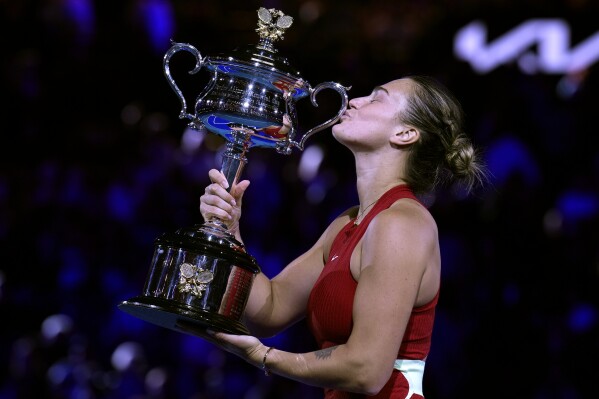 Aryna Sabalenka of Belarus kisses the Daphne Akhurst Memorial Cup after defeating Zheng Qinwen of China in the women's singles final at the Australian Open tennis championships at Melbourne Park, Melbourne, Australia, Saturday, Jan. 27, 2024. (AP Photo/Andy Wong)