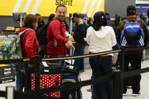 Travelers wait to check luggage into their Spirit Airlines at George Bush Intercontinental Airport, Tuesday, Nov. 21, 2023, in Houston. (Jason Fochtman/Houston Chronicle via AP)