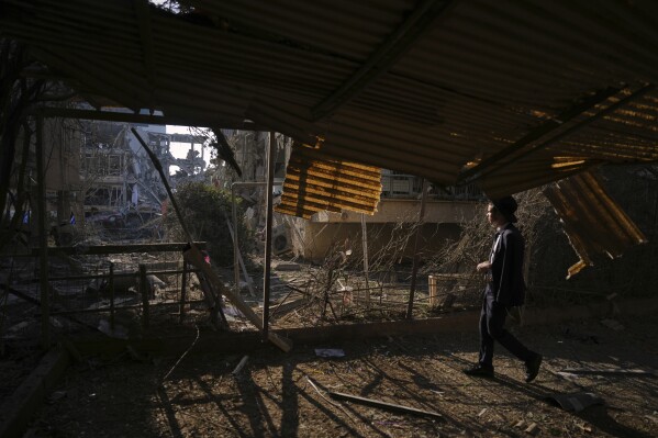 A person looks out at a destroyed residential building that was hit by a missile fired from Iran, in Ramat Gan, near Tel Aviv, Israel, on Saturday, June 14, 2025. (AP Photo/Ariel Schalit)