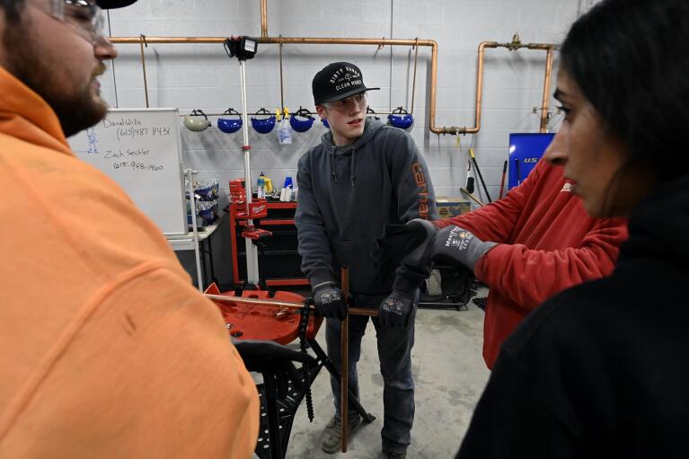 Boone Williams, 20, center, talks to other students in the apprentice training program class at the Plumbers and Pipefitters Local Union 572 facility in Nashville, Tenn., on Thursday, Feb. 2, 2023. Williams says eventually he expects to earn far more than friends who took quick jobs after high school. He even thinks he’s better off than some who went to college — he knows too many who dropped out or took on debt for degrees they never used. “In the long run, I’m going to be way more set than any of them,” he says. (AP Photo/Mark Zaleski)