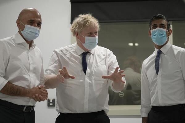 FILE - Britain's Prime Minister Boris Johnson, center, Rishi Sunak, Chancellor of the Exchequer, right, and Sajid Javid, Secretary of State for Health and Social Care speak together as they look at a CT scanner during a visit to the New Queen Elizabeth II Hospital, Welwyn Garden City, England, on April 6, 2022. Two of Britain’s most senior Cabinet ministers have quit, a move that could spell the end of Prime Minister Boris Johnson’s leadership after months of scandals. Treasury chief Rishi Sunak and Health Secretary Sajid Javid resigned within minutes of each other. (AP Photo/Frank Augstein, File