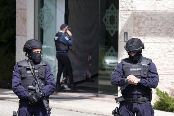 Police officers stand at the entrance of an Ismaili Muslim center in Lisbon, Portugal, Tuesday, March 28, 2023. Portuguese police have shot a man suspected of stabbing two people to death at an Ismaili Muslim center in Lisbon. Authorities said police were called to the center late Tuesday morning where they encountered a suspect armed with a large knife. (AP Photo/Armando Franca)