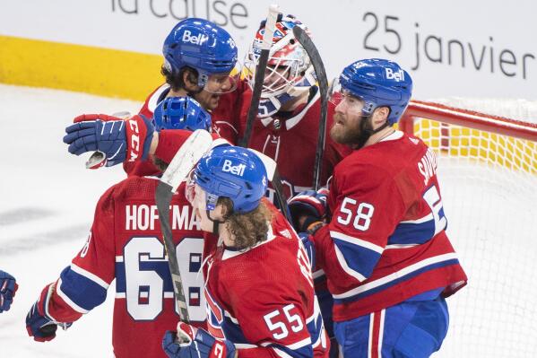 Montreal Canadiens goaltender Sam Montembeault, center, celebrates with teammates after defeating the Winnipeg Jets in an NHL hockey game, Tuesday, Jan. 17, 2023 in Montreal. (Graham Hughes/The Canadian Press via AP)