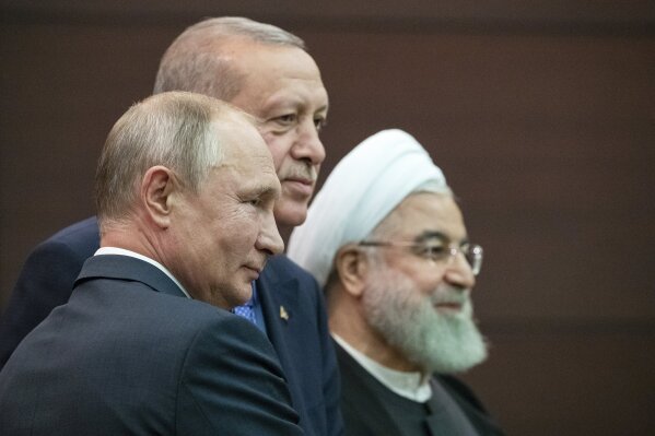 Russian President Vladimir Putin, left, Turkish President Recep Tayyip Erdogan and Iranian President Hassan Rouhani, right, pose for a picture after a news conference during their meeting in Ankara, Turkey, Monday, Sept. 16, 2019. The leaders of Russia, Iran and Turkey met in the Turkish capital to discuss the situation in Syria, with the aim of halting fighting in the northwest of the country and finding a lasting political solution to the 8 1/2 year civil war. (AP Photo/Pavel Golovkin, Pool)