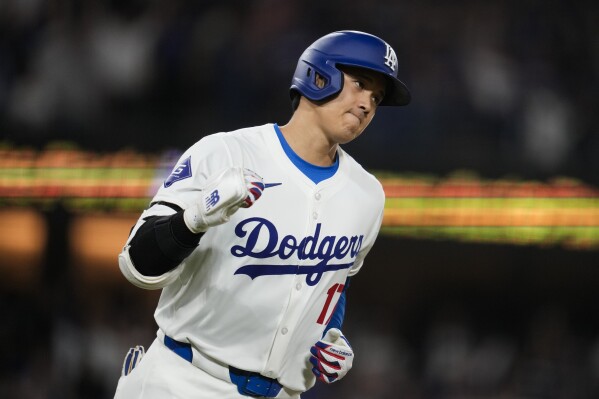 Los Angeles Dodgers designated hitter Shohei Ohtani celebrates as he runs the bases after hitting a home run during the seventh inning of a baseball game against the San Francisco Giants in Los Angeles, Wednesday, April 3, 2024. (AP Photo/Ashley Landis)