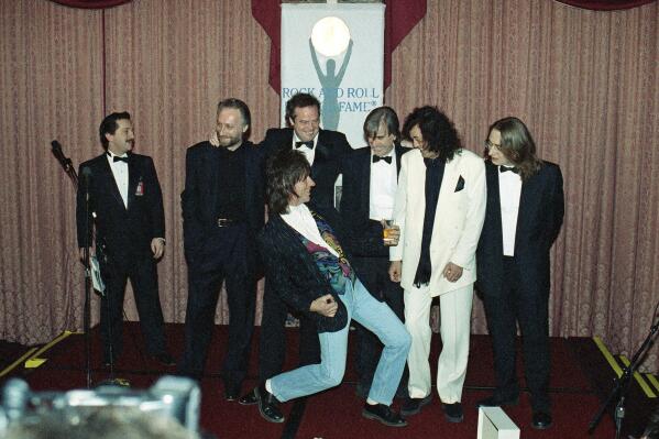 FILE - Jeff Beck plays the air guitar for Jimmy Page, second from right, as unidentified members of the Yardbirds look on at New York's Waldorf Astoria Hotel, on, Jan. 15, 1992, as the group was on hand for their induction during the Seventh Annual Rock and Roll Hall of Fame Dinner. Beck, a guitar virtuoso who pushed the boundaries of blues, jazz and rock 'n' roll, influencing generations of shredders along the way and becoming known as the guitar player's guitar player, died Tuesday, Jan. 10, 2023, after "suddenly contracting bacterial meningitis," his representatives said in a statement released Wednesday. He was 78. (AP Photo/Mark Lennihan, File)