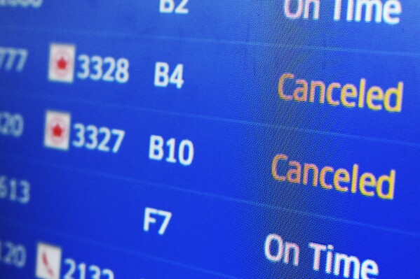 FILE - A United Airlines flight information screen displays flight information, including canceled flights, at O'Hare International Airport in Chicago, Jan. 14, 2024. Consumer groups are pushing Congress to uphold automatic refunds for airline passengers whose flights are canceled or delayed for several hours. (AP Photo/Nam Y. Huh, File)