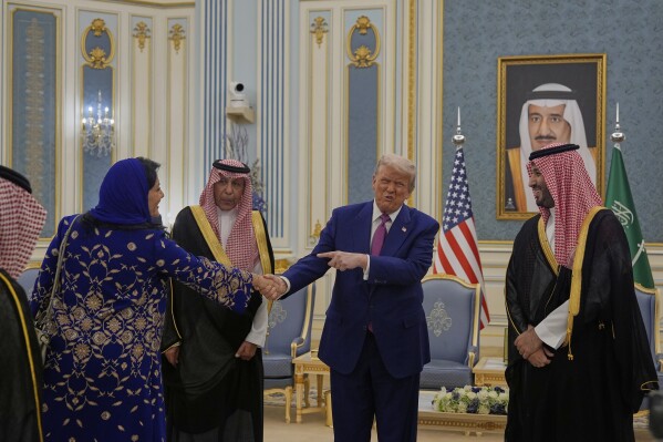 President Donald Trump gestures to Saudi Crown Prince Mohammed bin Salman as he greets Reema bint Bandar Al Saud, Saudi ambassador to the United States, at the Royal Palace in Riyadh, Saudi Arabia, Tuesday, May 13, 2025 (AP Photo/Alex Brandon)