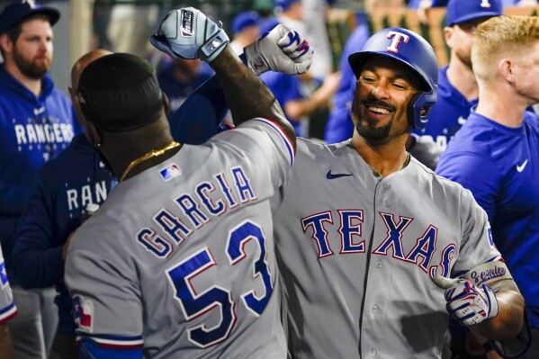 Texas Rangers' Marcus Semien, right, celebrates after his home run with Adolis Garcia during the seventh inning of a baseball game against the Los Angeles Angels, Monday, Sept. 25, 2023, in Anaheim, Calif. (AP Photo/Ryan S. Sun)