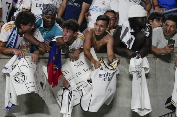 Fans try to get autographs from players after a Champions Cup soccer match between Juventus and Real Madrid, Wednesday, Aug. 2, 2023, in Orlando, Fla. (AP Photo/John Raoux)