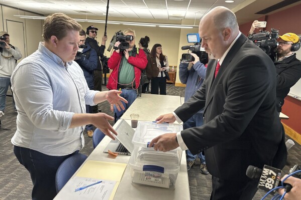 Matthew Snorek, right, submits petitions to force a recall election targeting Wisconsin's top elected Republican, Assembly Speaker Robin Vos, Monday, March 11, 2024, in Madison, Wis. Vos angered backers of former President Donald Trump when he refused to impeach the official who oversees the battleground state's elections. (AP Photo/Scott Bauer)