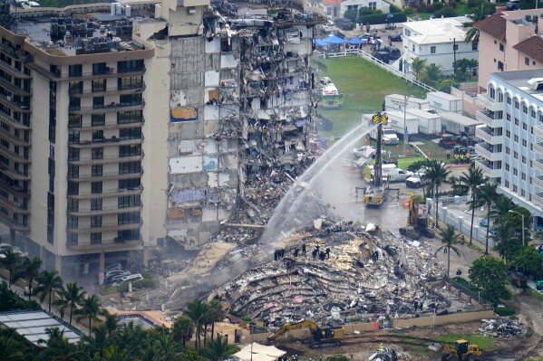 FILE - Rescue personnel work at the remains of the Champlain Towers South condo building, June 25, 2021, in Surfside, Fla. The swimming pool deck of the beachfront South Florida condominium where 98 people died when the building collapsed two years ago failed to comply with the original codes and standards, with many areas of severe strength deficiency, federal investigators said Thursday, June 15, 2023. (AP Photo/Gerald Herbert, File)