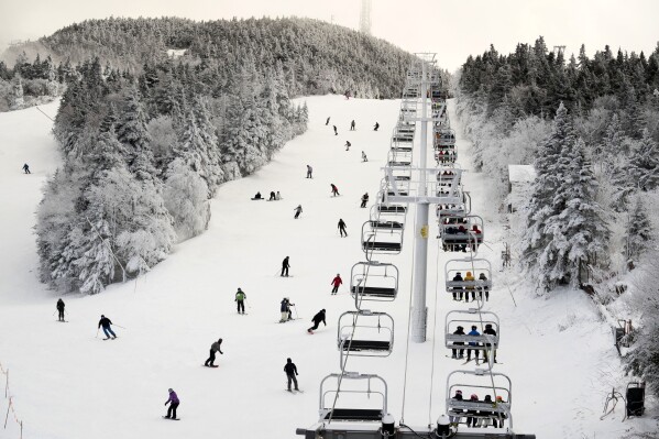 FILE - Thanksgiving holiday skiers descend near the North Ridge Quad chairlift, Nov. 24, 2023, at Killington Ski Resort in Killington, Vt. A new study says U.S. ski areas lost about $5 billion from 2000 to 2019 as a result of human-caused climate change. (AP Photo/Robert F. Bukaty, File)