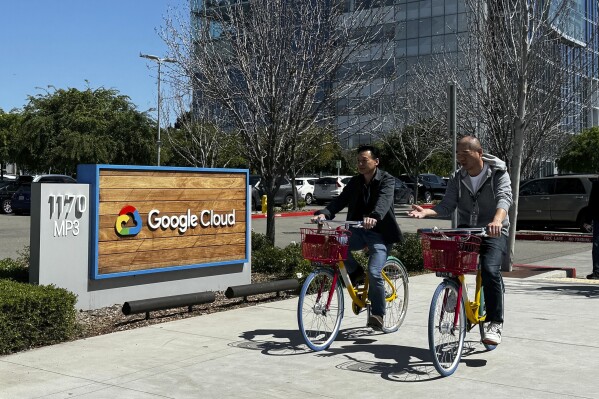 Two people ride past the Google sign outside the Google offices in Sunnyvale, Calif., on Thursday, April 18, 2024. Google has fired 28 employees who were involved in protests over the tech company’s cloud computing contract with the Israeli government. The workers held sit-ins at the company’s offices in California and New York over Google’s $1.2 billion contract to provide custom tools for Israeli’s military. (AP Photo/Terry Chea)