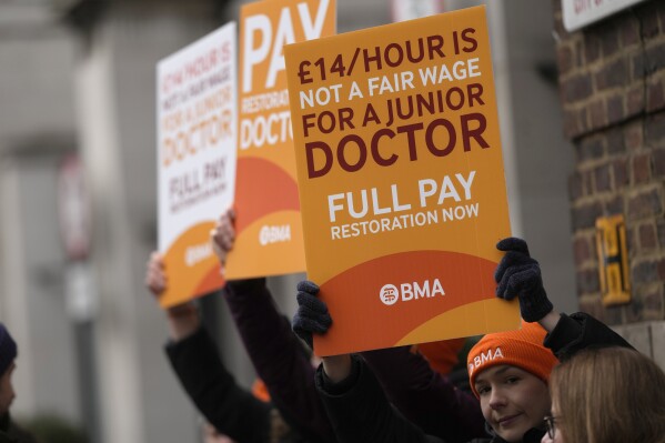 FILE - Junior doctors hold placards on a picket line outside St Mary's Hospital in London, Tuesday, March 14, 2023. Britain's government reached a deal with senior doctors in England that could potentially end a series of disruptive strikes, officials said Monday, Nov. 27, 2023. (AP Photo/Alastair Grant, File)