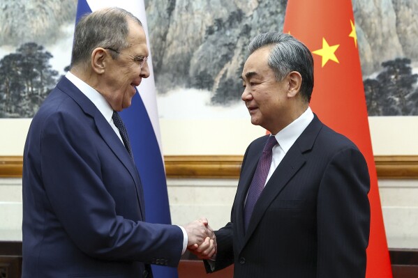 In this photo released by Russian Foreign Ministry Press Service on Tuesday, April 9, 2024, Russian Foreign Minister Sergey Lavrov, left, and Chinese Foreign Minister Wang Yi shake hands prior to their talks in Beijing, China. Russian Foreign Minister Sergey Lavrov is visiting Beijing to display the strength of ties with close diplomatic partner China amid Moscow's grinding war against Ukraine. (Russian Foreign Ministry Press Service via AP)