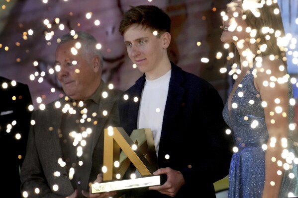 Slovenia's Tadej Pogacar poses as he receives the Velo d'Or award trophy during a ceremony, in Paris, Friday, Dec. 6, 2024. (AP Photo/Christophe Ena)