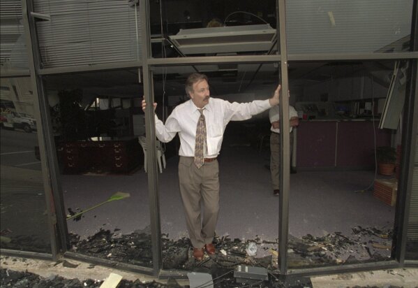 A man stands in the blown-out doorway of a downtown business a few blocks from the Alfred P. Murrah Federal Building, which was destroyed by a massive bomb, on April 19, 1995, in Oklahoma City. (AP Photo/Rick Bowmer, File)