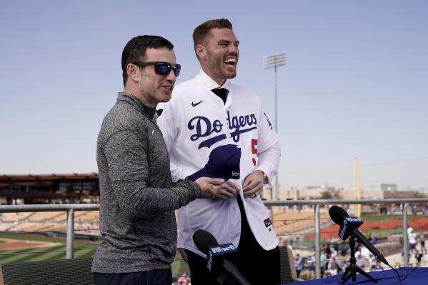 Los Angeles Dodgers president of baseball operations Andrew Friedman, left, announces the arrival of free agent Freddie Freeman during a news conference at spring training baseball, Friday, March 18, 2022, in Glendale, Ariz. (AP Photo/Charlie Riedel)