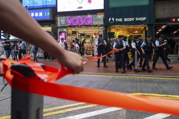 Police officers stand guard in the Causeway Bay area on the 36th anniversary of China's Tiananmen Square crackdown, in Hong Kong, Wednesday, June 4, 2025. (AP Photo/Chan Long Hei)