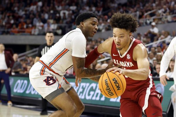 Alabama guard Mark Sears is fouled by Auburn guard K.D. Johnson as he breaks for the basket during the first half of an NCAA college basketball game, Saturday, Feb. 11, 2023, in Auburn, Ala. (AP Photo/Butch Dill)