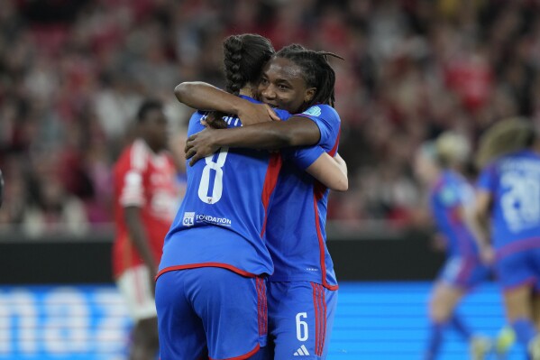 Lyon's Sara Daebritz, left, celebrates with her teammate Melchie Dumornay after scoring her side's second goal during the women's Champions League quarterfinals, first leg, soccer match between SL Benfica and Olympique Lyonnais at the Luz Stadium, in Lisbon, Tuesday, March 19, 2024. (AP Photo/Armando Franca)