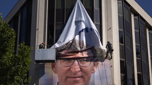 Workers remove an electoral poster showing Alberto Feijoo, leader of the mainstream conservative Popular Party, at the party headquarters in Madrid, Spain, Monday, July 24, 2023. Spaniards woke up Monday to find their country in political disarray after elections a day earlier left no party with a clear path to forming a government. (AP Photo/Emilio Morenatti)