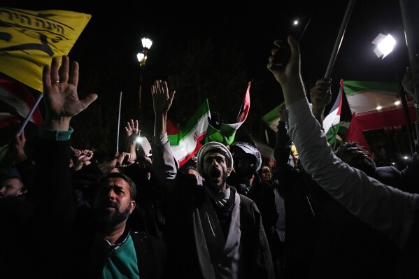Iranian demonstrators chant slogans during an anti-Israeli gathering in front of the British Embassy in Tehran, Iran, early Sunday, April 14, 2024. Iran launched its first direct military attack against Israel on Saturday. (AP Photo/Vahid Salemi)