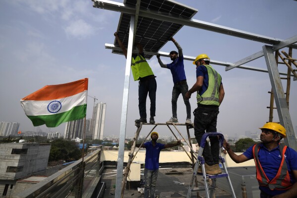 Workers of Solar Square place a panel on the rooftop of a residence in Gurugram on the outskirts of New Delhi, India, Feb. 20, 2024. (AP Photo/Manish Swarup, File)
