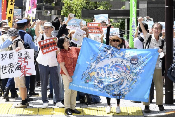 Un manifestante sostiene un cartel durante una manifestación contra la liberación de agua radiactiva tratada de la dañada planta de energía nuclear de Fukushima, frente a la sede de Tokyo Electric Power Company Holdings (TEPCO), el jueves 24 de agosto de 2023, en Tokio.  El operador de la planta de energía nuclear Fukushima Daiichi, destruida por el tsunami, comenzará a liberar el primer lote de aguas residuales radiactivas tratadas y diluidas en el Océano Pacífico más tarde el jueves, dijeron ejecutivos de la empresa de servicios públicos. (Foto AP/Norihiro Haruta)