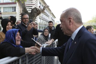 
              Turkey's President Recep Tayyip Erdogan shakes hands with a supporter as he arrives to speak at an assembly for religious schools, in Istanbul, Saturday, April 13, 2019. Erdogan's ruling party still appealing the results of the local elections in Istanbul, where the opposition has a razor-thin lead and Erdogan said Wednesday election results in Istanbul should be canceled over irregularities.(Presidential Press Service via AP, Pool)
            
