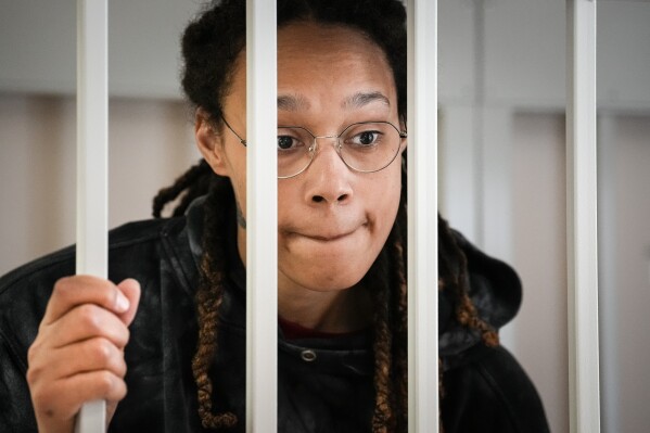 FILE - WNBA star and two-time Olympic gold medalist Brittney Griner speaks to her lawyers from inside a cage in a courtroom in Khimki, outside Moscow, Russia, on July 26, 2022. Griner continues her efforts to settle into a normal routine following her release from a Russian prison 17 months ago. (AP Photo/Alexander Zemlianichenko, Pool, File)