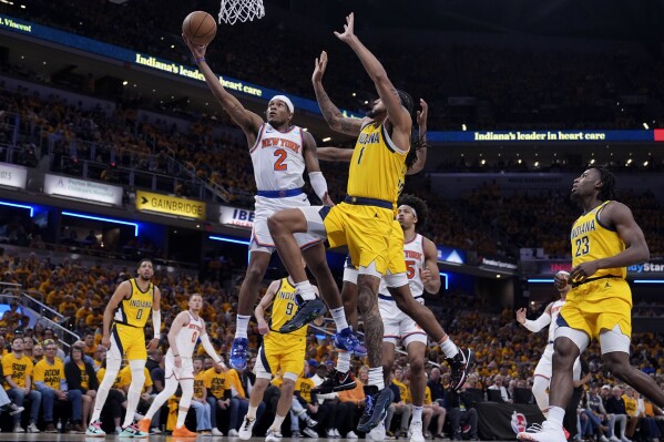 New York Knicks guard Miles McBride (2) drives to the basket past Indiana Pacers forward Obi Toppin (1) during the first half of Game 3 in an NBA basketball second-round playoff series, Friday, May 10, 2024, in Indianapolis. (AP Photo/Michael Conroy)