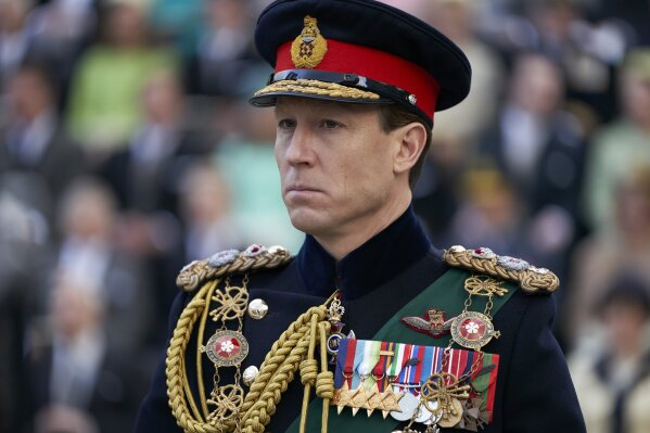 In this image released by Netflix, Tobias Menzies portrays Prince Philip in a scene from the third season of "The Crown." Britain's Prince Philip stood loyally behind behind Queen Elizabeth, as his character does on Netflix's “The Crown.” But how closely does the TV character match the real prince, who died Friday, April 9, 2021 at 99? Philip is depicted as a man of action in “The Crown,” and he served with distinction in the navy in World War II. He was also an avid yachtsman and polo player. (Des Willie/Netflix via AP)