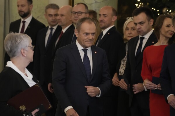 Poland's new Prime Minister Donald Tusk, centre, walks past ministers during the swearing-in ceremony at the presidential palace in Warsaw, Poland, Wednesday, Dec. 13, 2023. Donald Tusk was sworn in by the president in a ceremony where each of his ministers was also taking the oath of office. (AP Photo/Czarek Sokolowski)